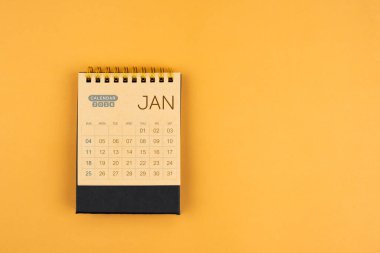 Sarı zemin üzerine kahverengi el sanatları takvimi Ocak 2026.