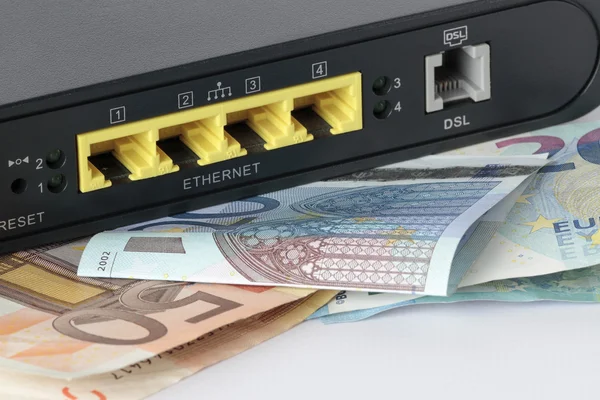 Primeiro plano da parte de trás de um router com algumas notas de euro — Fotografia de Stock