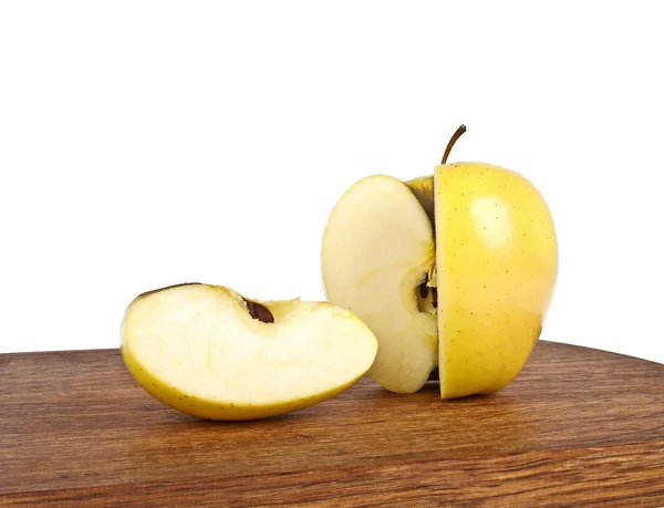 Manzana amarilla y rebanada en tabla de cortar de madera sobre un fondo blanco — Foto de Stock