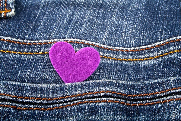 Coração violeta no bolso de jeans — Fotografia de Stock