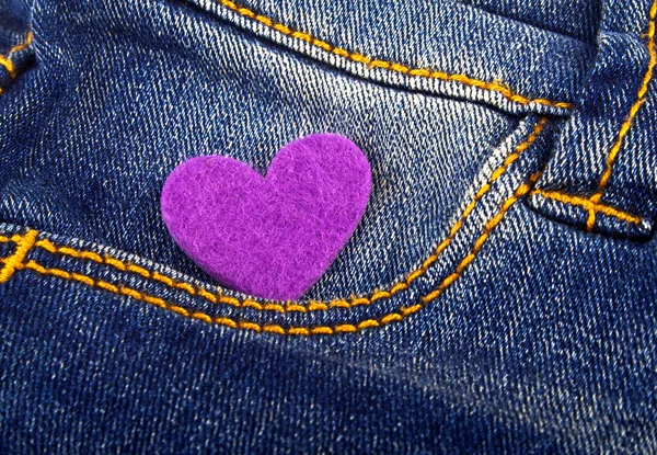 Coração violeta no bolso de jeans — Fotografia de Stock
