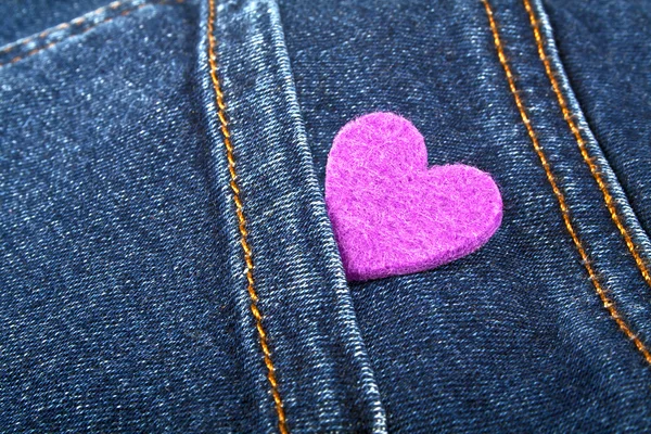 Coração roxo no bolso de jeans — Fotografia de Stock