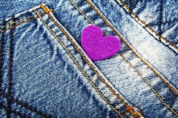 Coração roxo no bolso de jeans — Fotografia de Stock