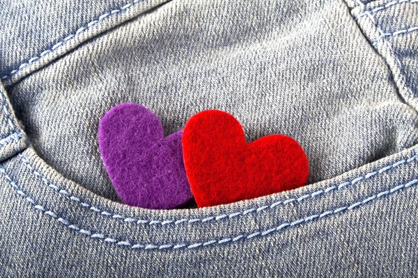 Corações vermelhos e violetas no bolso jeans — Fotografia de Stock