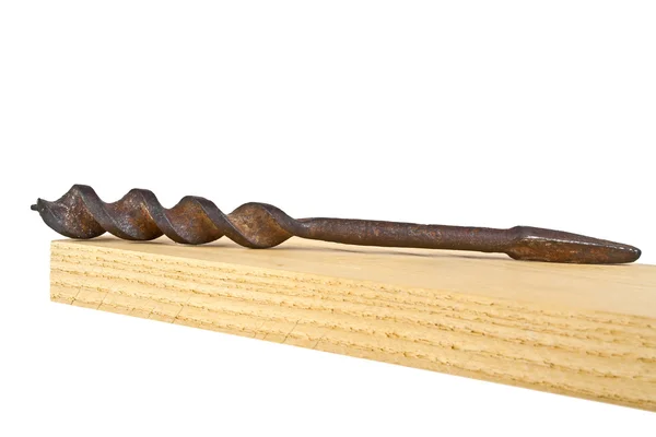 Velha broca enferrujada na prancha de madeira em um fundo branco — Fotografia de Stock