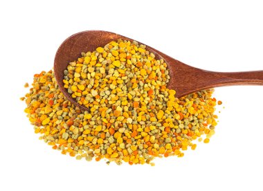 Beyaz arka planda izole edilmiş tahta kaşıktaki arı poleni.