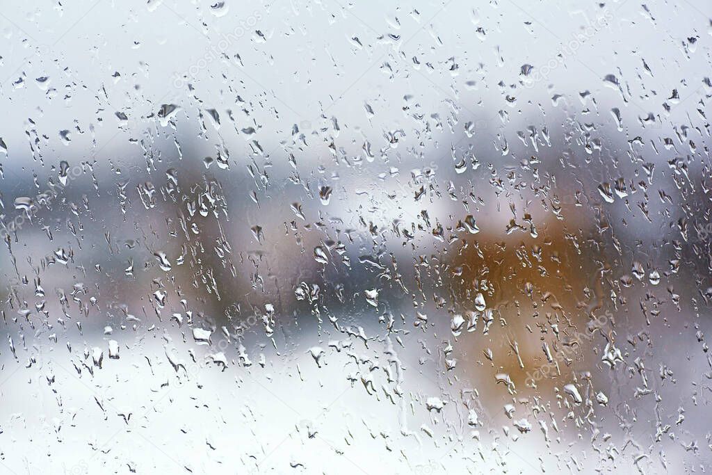 Rainy city background. Raindrops on window glass. Wet home window with raindrops.