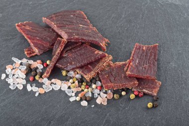 Kurutulmuş et, karabiber ve siyah taş masada deniz tuzu. Seçici odak.