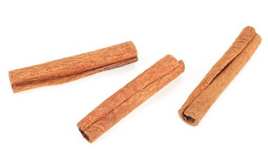 Beyaz arka planda üç tarçın çubuğu, üst manzara.
