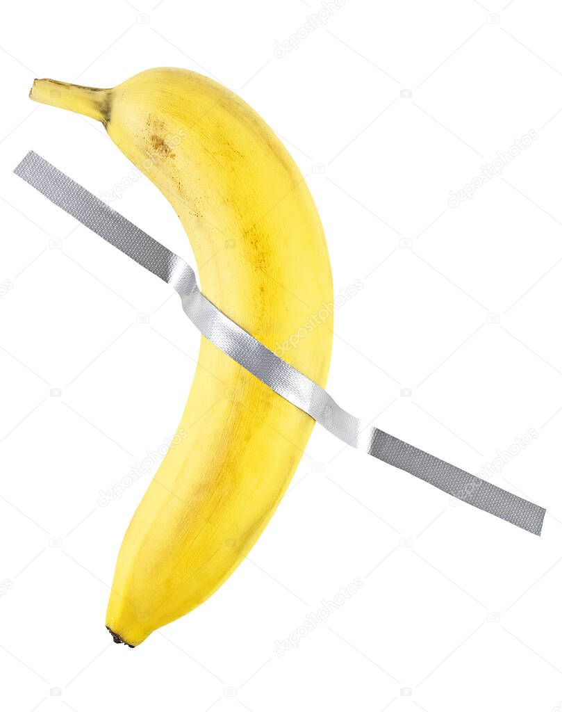 Banana duct taped to the white wall. Yellow banana on the white wall.