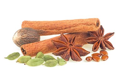 Traditional Christmas spices - cinnamon sticks, star anise, nutmeg and cardamom pods isolated on a white background.