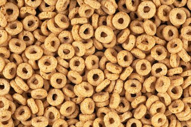 Arka plan olarak gevrek kuru kahvaltı halkaları, üst manzara. Mısır gevreği arka planı. Tam tahıllı mısır gevreği..