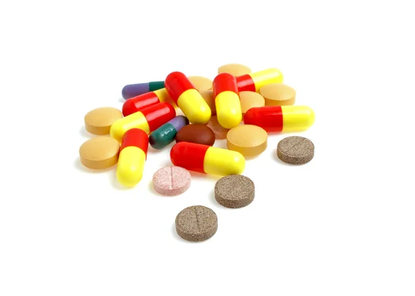 Pilules et comprimés colorés sur fond blanc — Photo