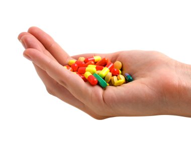 Elinde beyaz bir arka plan üzerinde renkli hapları 