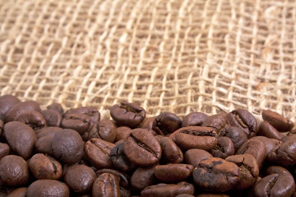 Coffee beans on burlap background — Stock Photo, Image