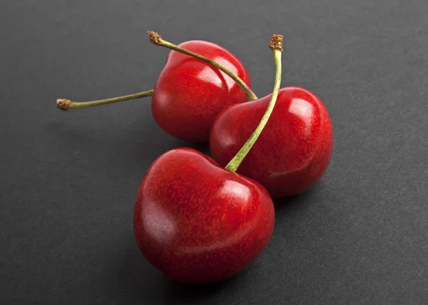 Bayas de cereza aisladas sobre un fondo negro — Foto de Stock