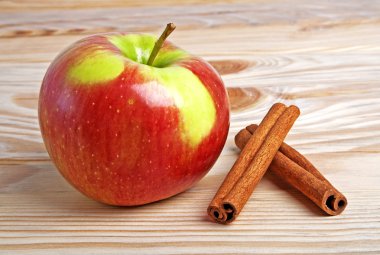 Ahşap zemin üzerine tarçın ile kırmızı elma