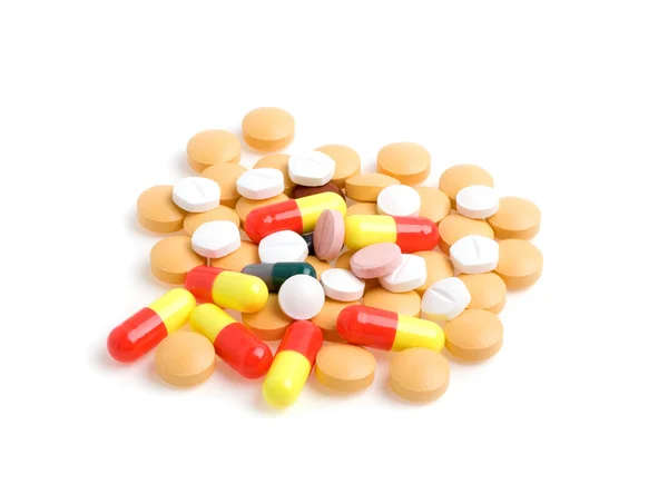 Pilules et comprimés colorés sur fond blanc — Photo