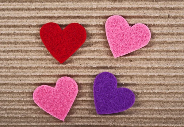 Цветные сердца на гофрированном картоне — стоковое фото
