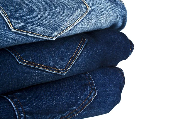 Lot of different blue jeans isolated on white background — Stock Photo, Image