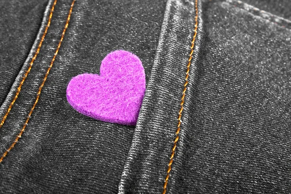 Coração roxo no bolso de jeans — Fotografia de Stock
