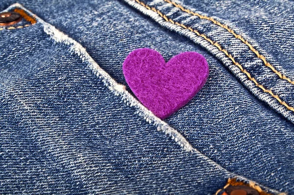 Coração roxo no bolso de jeans — Fotografia de Stock