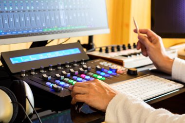 Müzik yapımcısı kontrol yüzeyinde ses parçalarını düzenleyip karıştırıyor. müzik üretim konsepti