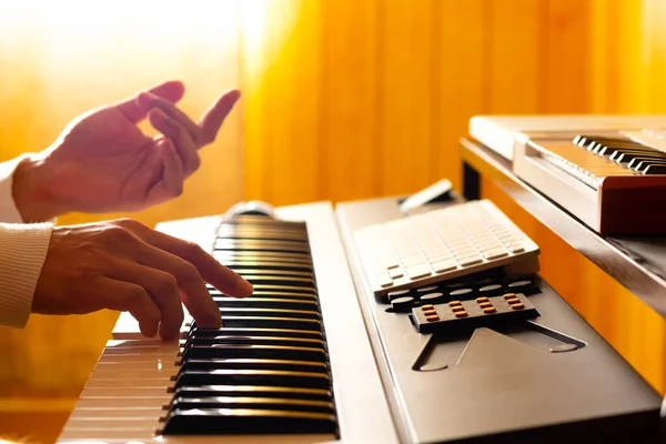自宅のスタジオでエレキピアノの鍵盤で演奏する作曲家の手のシルエット 閉めろ 音楽の背景 — ストック写真