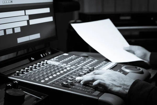 ポストプロダクションスタジオでオーディオミキシングボードの音量を調整するサウンドエンジニアの手 — ストック写真