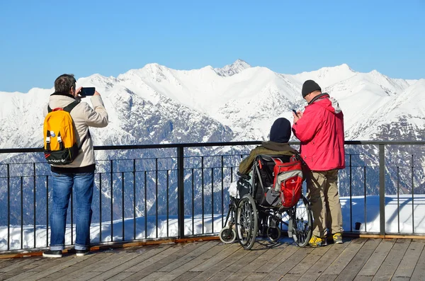 Sochi, Russia, February, 29, 2016, Ski resort Rosa Khutor. People look at of mountains from the observation deck of Rosa peak