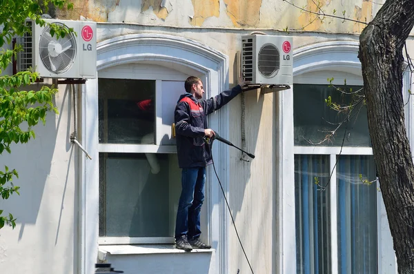 Vladivostok, Russia, May, 16, 2016. Worker cleaning air conditioning