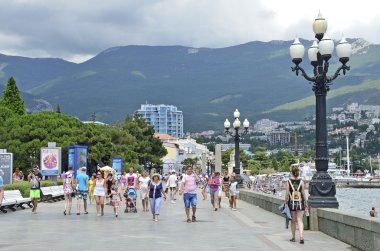 Yalta, Kırım'da, Temmuz, 20, 2016. Kırım'da, bulutlu bir günde Yalta sahil üzerinde yürüyen insanlar