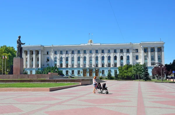 Simferopol, la Crimea 14 de julio de 2016. Mujer con un cochecito caminando en la plaza Lenin cerca del edificio del Gobierno de la República de Crimea en verano —  Fotos de Stock