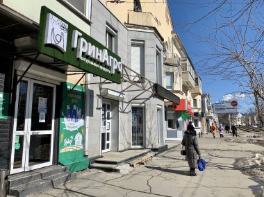 Vladivostok, Rusya, Mart, 06, 2021. Vladivostok 'taki Borisenko Caddesi' nde Yeşil Tarım Marketi 'nde yürüyen bir kadın.