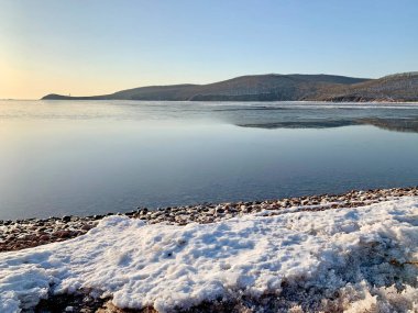 Güneşli kış sabahında Shkot adasının kıyısında. Vladivostok, Rusya