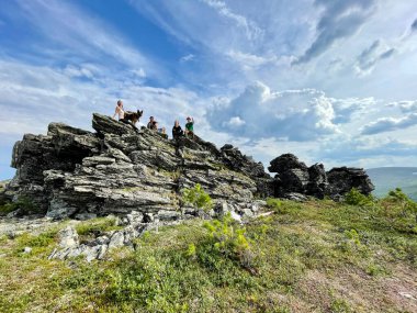 Dyatlov geçidi, Kuzey Ural, Rusya, Temmuz 08, 2021 Turistler yazın Dyatlov geçidinde büyük bir taşın üzerinde. Kuzey Ural