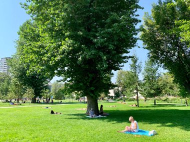 Moskova, Rusya, 18 Ağustos 2021. İnsanlar yaz aylarında Moskova 'da N. N. Pryamikov' un adını alan Tagansky Çocuk Parkı 'ndaki çimlerde dinleniyorlar.