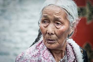 LHASA, Tibet, Çin - 17 Ağustos 2018: Jokhang tapınağının önündeki hacılar. Barkhor Meydanı 'ndaki Budist Tapınağı Tibet' teki en kutsal ve önemli tapınaktır..