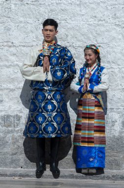 LHASA, TIBET, ÇİN - 17 AĞUSTOS, 17 2018: Jokhang tapınağının önünde kimliği belirsiz Tibetli çift. Barkhor Meydanı 'ndaki Budist Tapınağı Tibet' teki en kutsal ve önemli tapınaktır..