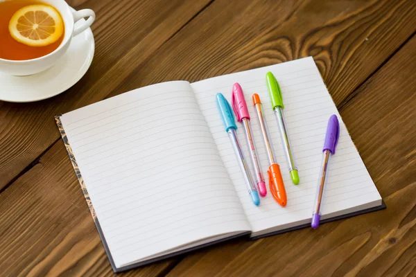 Открыть блокнот с пустыми страницами и цветными ручками — стоковое фото