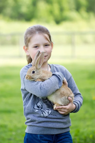 La niña en la calle para sostener un conejo vivo — Foto de Stock