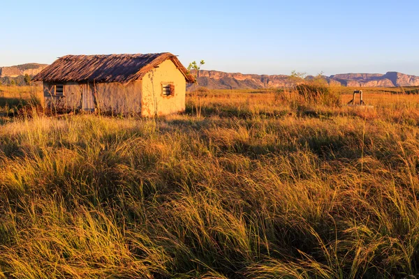 Casa em uma paisagem africana ao nascer do sol — Fotografia de Stock