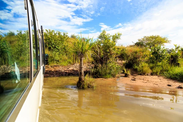Afrika'da kırsal manzara bir otobüs ile bir nehir geçiş — Stok fotoğraf