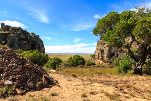 Formazioni rocciose ripide con valle sullo sfondo illuminata dal sole — Foto Stock