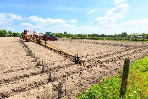 Trattore che lavora su un campo coltivato in un paesaggio di campagna — Foto Stock