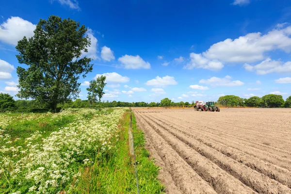 トラクター作業は、田舎風景の中栽培フィールド — ストック写真