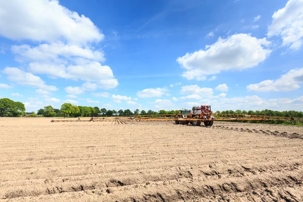 Trattore che lavora su un campo coltivato in un paesaggio di campagna — Foto Stock