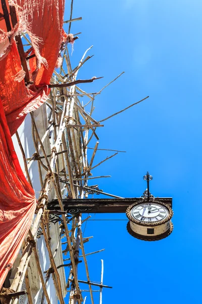 Reloj colonial colgando de un viejo edificio colonial — Foto de Stock