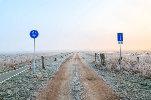 Man walking on a sand road in a winter landscape — Stock Photo, Image