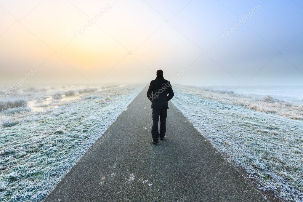 Man walking on an empty desolate raod